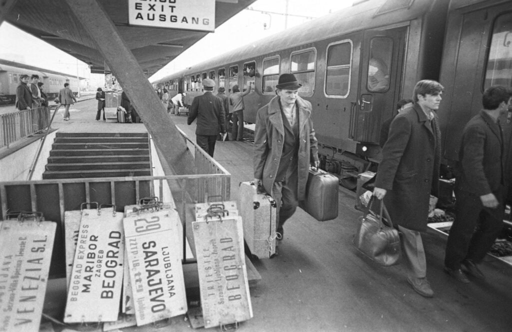 Železniška postaja, potniki se vkrcajo na vlak.