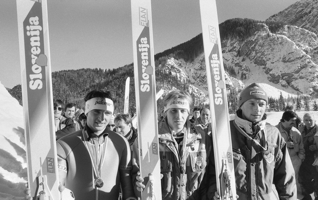 Smučarji držijo smuči v rokah.