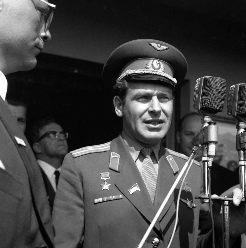 Titov stoji pred mikrofonom.