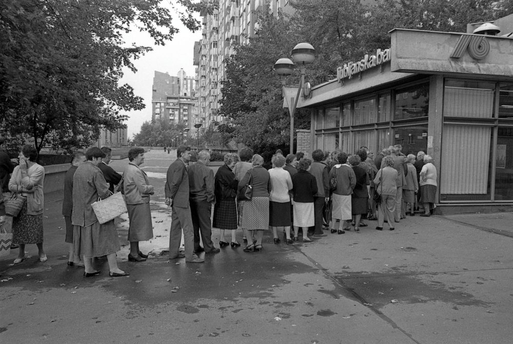 Ljudje čakajo na vstop v banko.