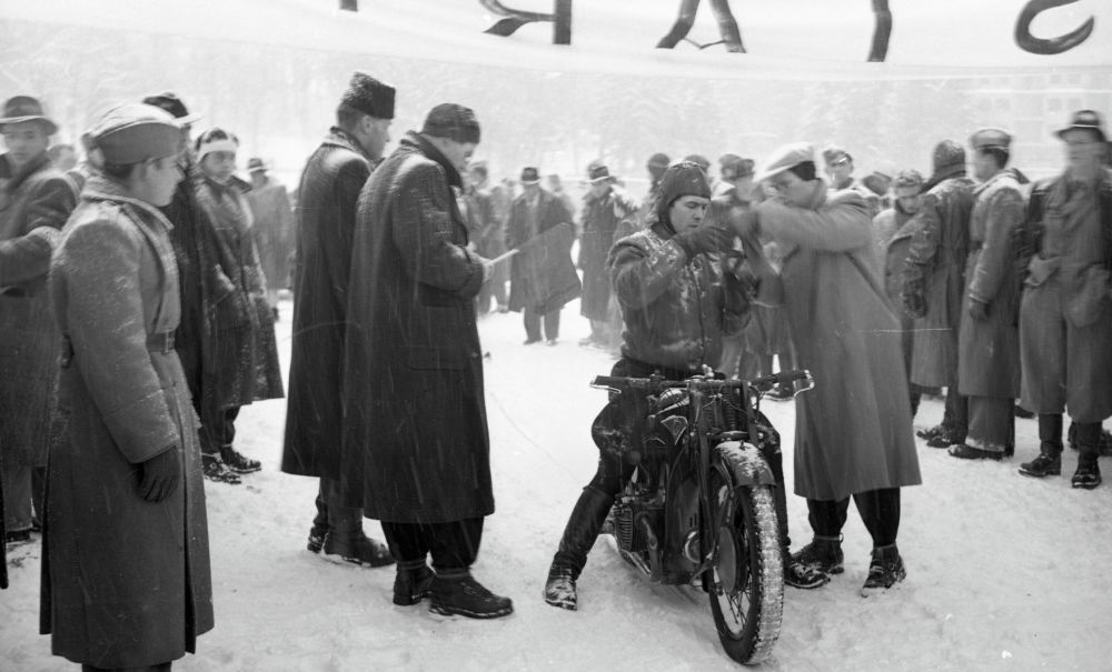 Motorist, okoli njega množica.