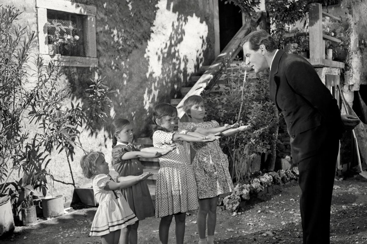 Igralec Bert Sotlar med pregledovanjem čistoče rok. Deklice z iztegnjenimi rokami.