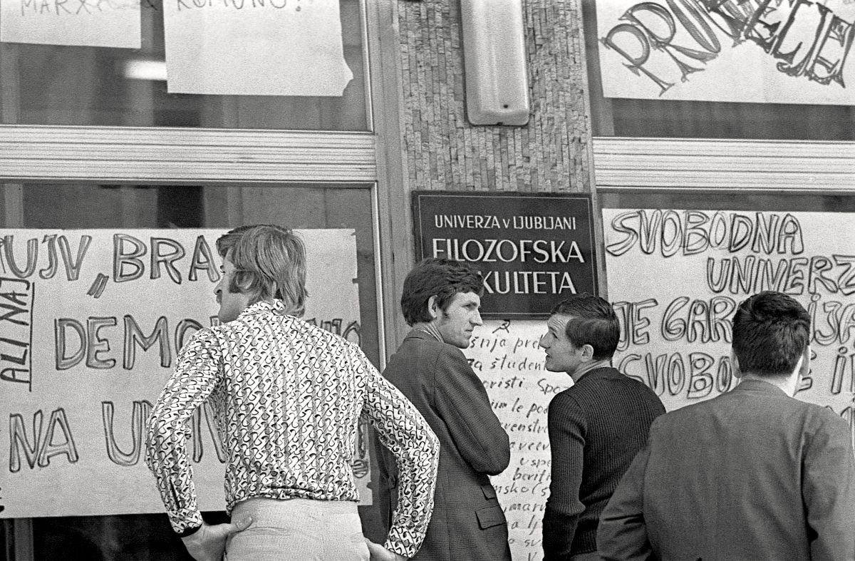 Študentje med branjem protestnih plakatov.