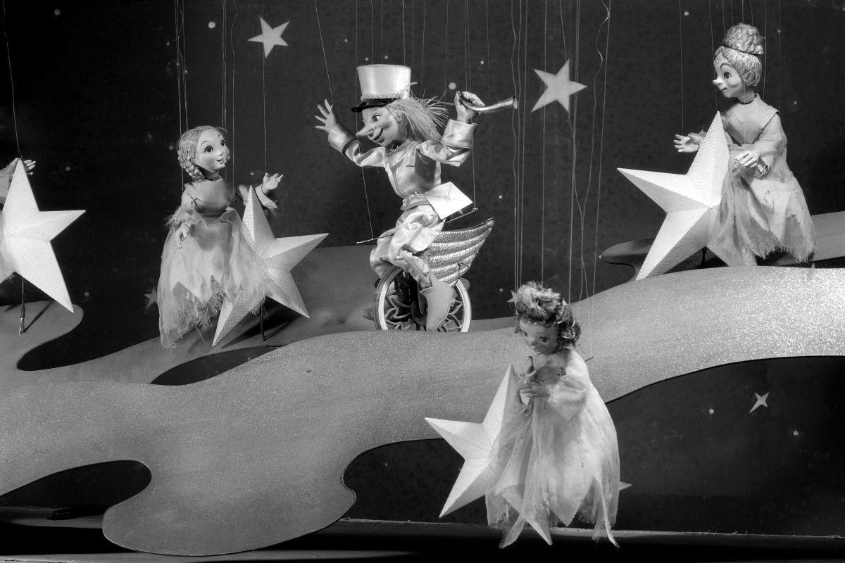 Gledališki oder in lutkovna predstava Zvezdica Zaspanka. Na odru tri zvezdice in pismonoša Komet Repatec. Zvezde in nebo.