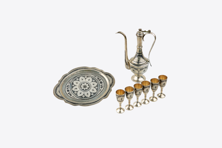 Set iz srebra s čajnikom, šestimi kozarčki in pladnjem, okrašen s tradicionalno orientalsko ornamentiko.