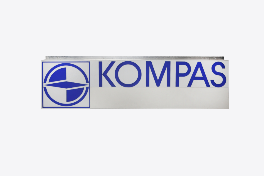 Tabla z znakom in napisom podjetja Kompas.